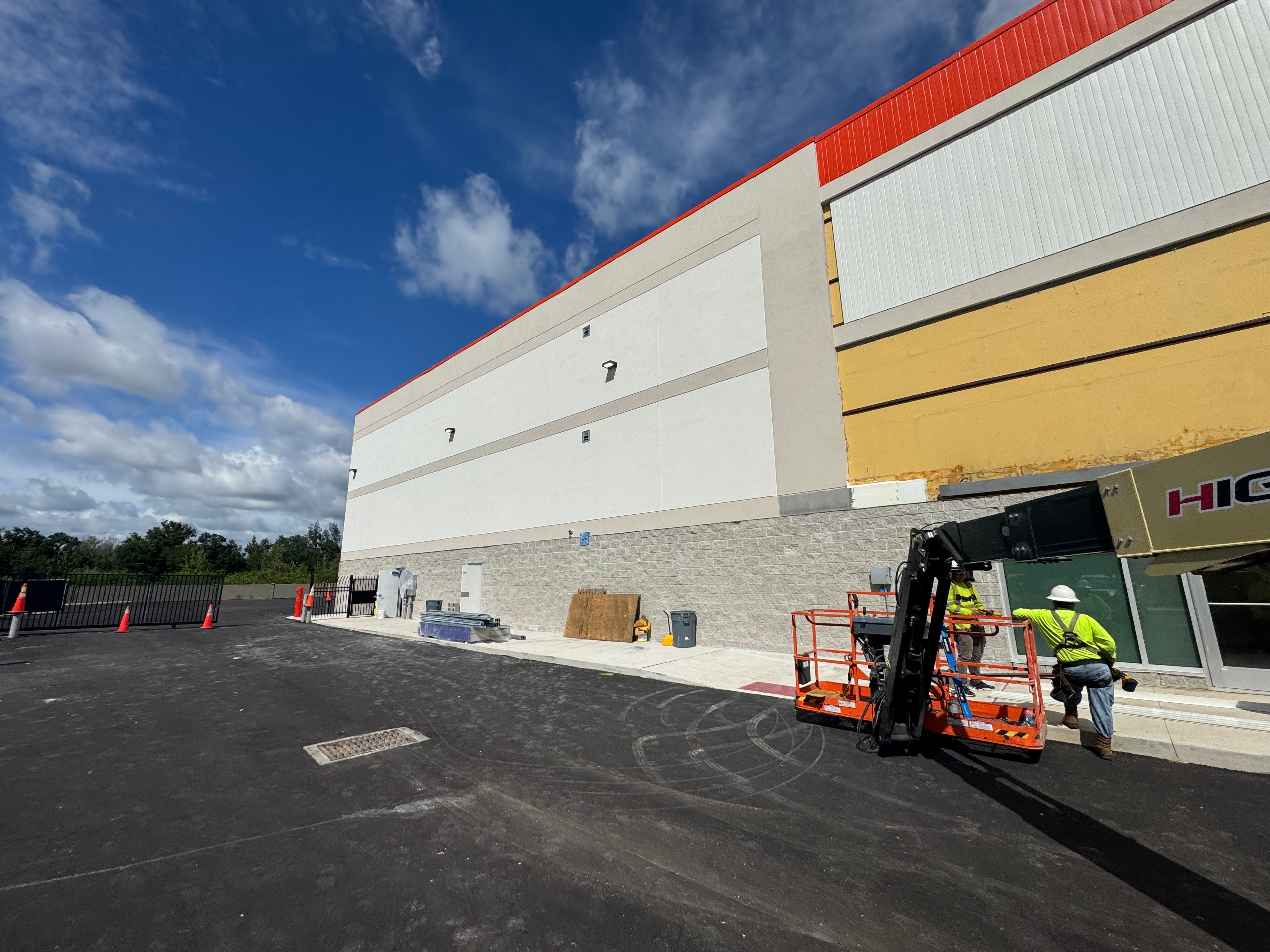 Public Storage building under construction side view with crew on lift