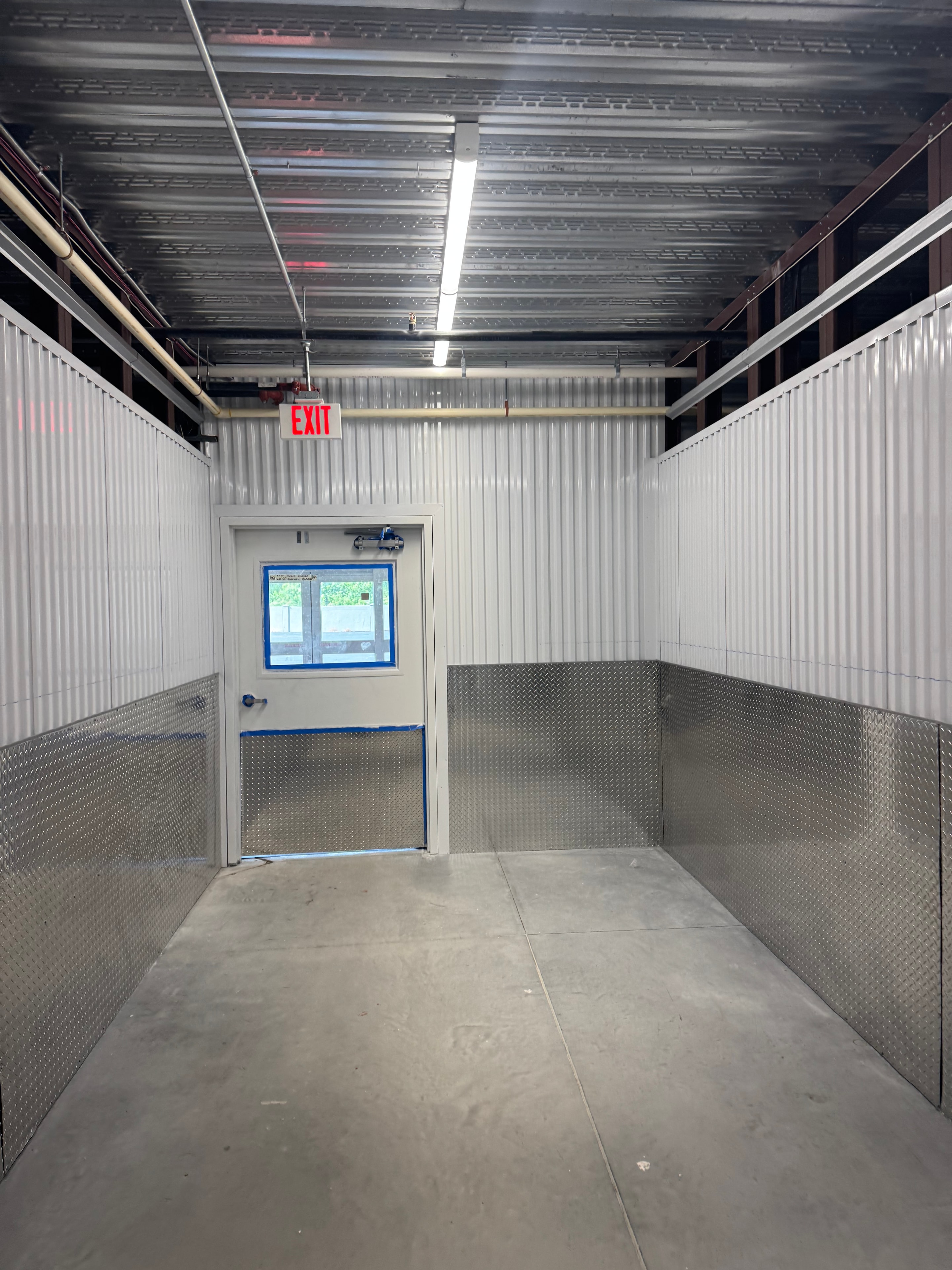 Public Storage interior corridor with exit signage and electrical work